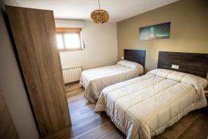 a bedroom with two beds and a window at Casa Rural Mario in Espeja