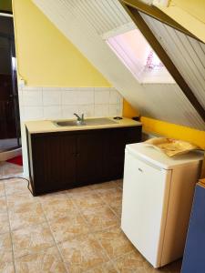 a kitchen with a sink and a refrigerator at Foothills loft in Keratea