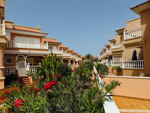 a row of apartment buildings with plants and flowers at Hugo's holiday apartment in Costa del Silencio in Arona