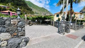 a stone wall next to a house at Marialina, By OP in São Vicente