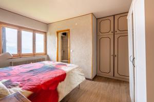 a bedroom with a bed with a red blanket at Appartamento Milollo Polsa in Brentonico