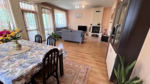 a dining room and living room with a table and a couch at Къща Каменар in Pomorie