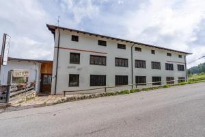 a white building on the side of a street at Appartamento Milollo Polsa in Brentonico
