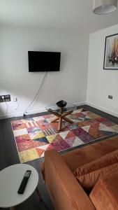 a living room with a couch and a table and a tv at Cozy City Apartment in Rainham in Rainham