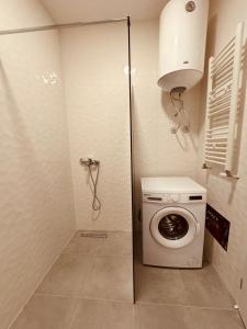 une petite salle de bains avec lave-linge et lave-linge. dans l'établissement Spacious apartment next to Royall Mall on B Street, à Pristina