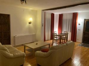 a living room with a couch and a table at Casuta din Padure in Bodeşti