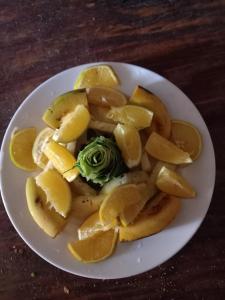 a white plate of food with oranges and lemons at Elephant trails camp in Sekenani