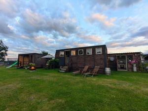 a house with a yard with chairs and a playground at Highview Hideaway in Upchurch