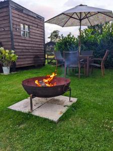 a fire pit in a yard with a table and an umbrella at Highview Hideaway in Upchurch