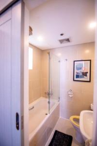 a bathroom with a tub and a toilet and a sink at Antel Spa & Serenity Suites in Manila