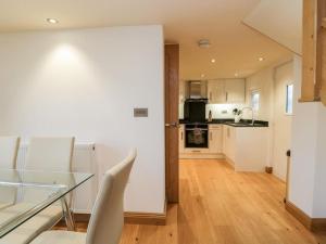 una cucina e una sala da pranzo con tavolo e sedie in vetro di Bridge Cottage a Newby Bridge