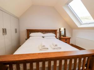 una camera da letto con un letto con due asciugamani sopra di Bridge Cottage a Newby Bridge