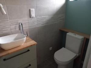a bathroom with a white sink and a toilet at Petit studio independant mitoyen à la maison in Jaunay-Clan