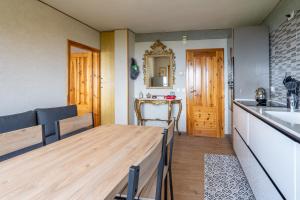 a kitchen and dining room with a wooden table at Appartamento Milollo Polsa in Brentonico +5 photos