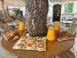 a table topped with sandwiches and pastries and orange juice at Apartamento Café Bernal in Tarifa