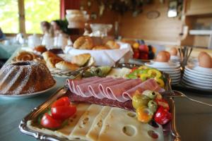 uma mesa coberta com um tabuleiro de comida com carne e produtos hortícolas em Hotel Tischlbergerhof em Ramsau am Dachstein