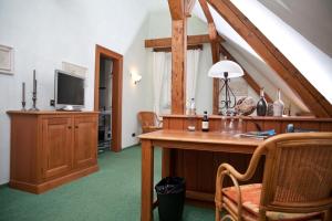 a room with a desk and a tv in a room at Hotel Alte Schule - Gasthaus Rose in Espelkamp