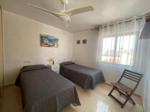 a bedroom with two beds and a ceiling fan at Mero Habitaciones in Cabo de Palos