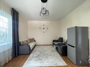 a living room with a couch and a clock on the wall at Dastan in Cholpon-Ata
