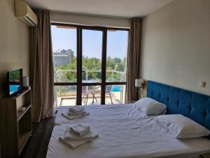 ein Hotelzimmer mit einem großen Bett mit Handtüchern darauf in der Unterkunft APART SUN Travel SUNNY BEACH in Sonnenstrand + 64 Fotos