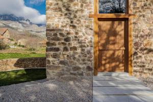MogrovejoにあるApartamentos Luarnaの山を背景にした石造りの建物への扉