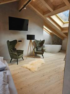 a bathroom with two chairs and a tub and a television at Chalet zur Auszeit in Mittenwald