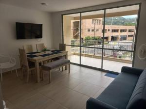 a living room with a table and a view of a building at Apartamento Ámbar Villeta in Villeta