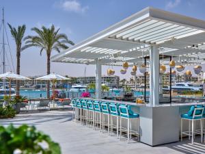 un bar con sedie e ombrelloni su un patio di Vida Marina Resort Marassi a El Alamein