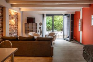 a living room with orange walls and a couch at Smartappart Caen Grusse in Caen