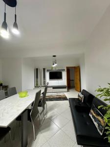 a living room with a table and chairs and a television at Armonia dell'Etna in Santa Venerina
