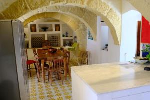 a kitchen and dining room with a table and chairs at Casa Palma Gozo in Għarb