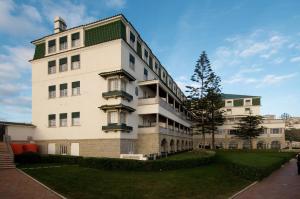 a large white building with a green roof at Vila Gale Ericeira in Ericeira