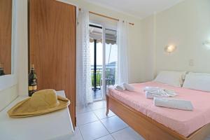 a bedroom with a bed with a hat and a window at S8 room in Nikiana +11 photos