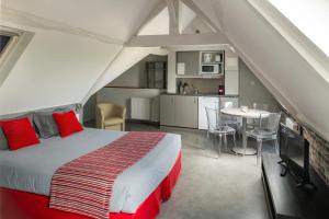 a bedroom with a bed and a table and a kitchen at Smart Appart Caen R&eacute;publique in Caen