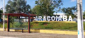 a bus stop in front of a sign on a street at hostel Araçoiaba in Araçoiaba