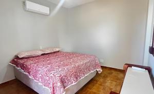 ein Schlafzimmer mit einem Bett mit einer rosa Tagesdecke in der Unterkunft House Relax Parque das Águas Quentes - Apê 2 Quartos in Caldas Novas + 32 Fotos