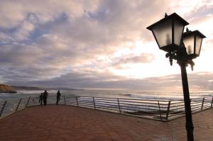 two people standing on a pier near the ocean at Vila Gale Ericeira in Ericeira