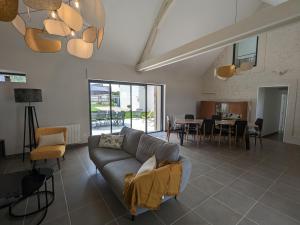 un soggiorno con un divano e un tavolo di Gîte spacieux et rénové avec jardin, proche châteaux de la Loire, pour 10 pers. - FR-1-590-361 a Huisseau-sur-Mauves