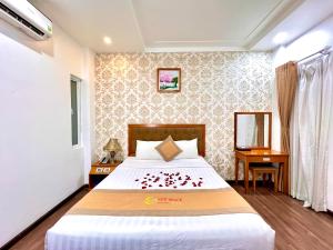 a bedroom with a bed with red flowers on it at New Space Hotel Airport in Ho Chi Minh City
