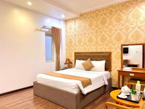 a bedroom with a bed and a table and a desk at New Space Hotel Airport in Ho Chi Minh City