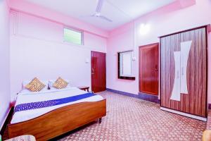 迪布鲁加尔Hotel O NANDINI的一间卧室设有一张大床和一扇门