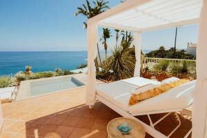 a swing on a patio with the ocean in the background at Hotel Continental Mare in Ischia