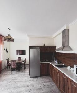 a kitchen with a stainless steel refrigerator and a table at Vip House Hotel in Astana