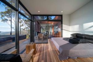 - une chambre avec un lit et de grandes baies vitrées dans l'établissement Mountain Top Snug, House Itas, à Snug