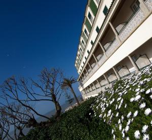 a building with white flowers in front of it at Vila Gale Ericeira in Ericeira