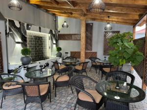a restaurant with tables and chairs in a room at Lux Plaza Hotel EVN airport in Arbatʼ