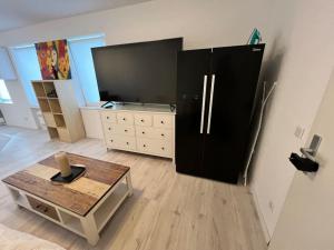 a living room with a black refrigerator and a table at Krefeld Zentrum Appartement Hubi2 in Krefeld