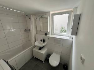 a bathroom with a sink and a toilet and a window at Krefeld Zentrum Appartement Hubi2 in Krefeld