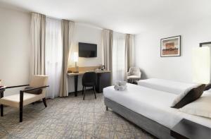 a hotel room with a bed and a desk at H&ocirc;tel Eliseo in Lourdes