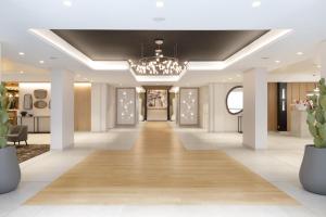 a corridor of a hotel with a chandelier at H&ocirc;tel Eliseo in Lourdes